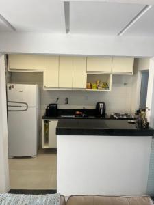 een keuken met witte kasten en een witte koelkast bij Apatapamento 2 quartos com excelente localização, segurança e com tudo o que você e sua família precisam pra uma estadia confortável! in Feira de Santana