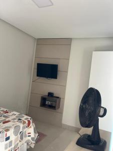 een slaapkamer met een ventilator en een muur met een tv bij Apatapamento 2 quartos com excelente localização, segurança e com tudo o que você e sua família precisam pra uma estadia confortável! in Feira de Santana
