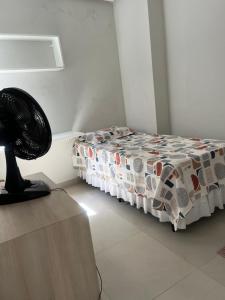 een slaapkamer met een bed met een dekbed en een ventilator bij Apatapamento 2 quartos com excelente localização, segurança e com tudo o que você e sua família precisam pra uma estadia confortável! in Feira de Santana +1 foto