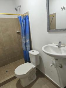 a bathroom with a toilet and a sink at La gran mansión en el centro de Pereira in Pereira