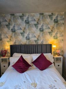 a bedroom with a bed with purple pillows at Charming 2 Bed Modern Guest House with Free Parking up to 3 cars in Beeston
