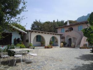 a patio with chairs and a table in front of a house at Agriturismo Camisadu in Oliena