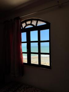 uma janela num quarto com vista para o oceano em Pousada Canto Maraú em Macaé