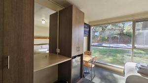 a room with a kitchen and a bed and a window at Bright Motor Inn in Bright