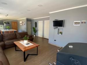 a living room with a couch and a table at Casa Pichilemu in Pichilemu