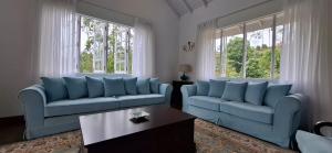 a living room with two blue couches and a table at LilyRose Bungalow at Willows, Upcot, Sri Lanka 