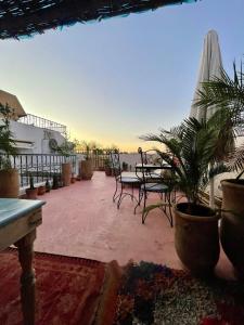 eine Terrasse mit Tisch, Stühlen und Sonnenschirm in der Unterkunft Riad Dar Malwan Hotel and Massage in Marrakesch + 82 Fotos