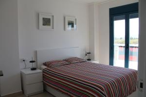 デニアにあるLas Olas Deniaの白いベッドルーム(ストライプ毛布付きのベッド付)