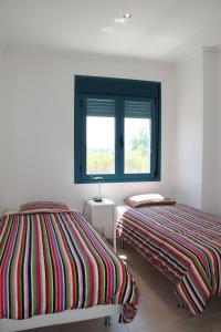 two beds sitting next to each other in a bedroom at Las Olas Denia in Denia