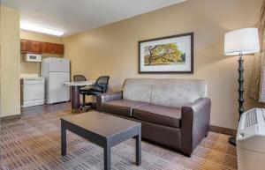 a living room with a couch and a table at Studio 6 Suites Jacksonville Deerwood Park FL in Deerwood Club