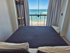 a bedroom with a bed with a view of the ocean at Hibisco Guest House in Florianópolis