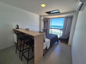 a small room with a desk and a bed and a window at Hibisco Guest House in Florianópolis