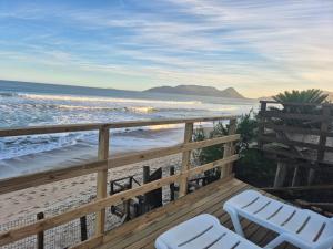 a balcony with two chairs and the beach at Hibisco Guest House in Florianópolis