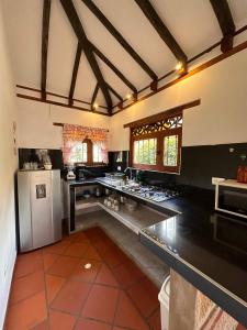 a large kitchen with black counters and a white refrigerator at Cabañas Villa Encanto in Villa de Leyva