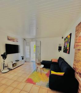 ein Wohnzimmer mit Sofa und Fernseher in der Unterkunft Villa Krysleen in Le Diamant