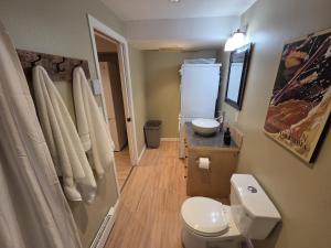 une salle de bain avec des toilettes blanches et un lavabo dans l'établissement NEW Midtown Rossland Studio Apartment, à Rossland