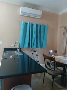 a room with a sink and a table and a chair at ToniqueluxeGuesthouse in Montego Bay