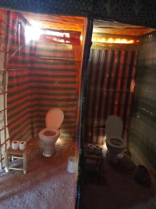 La salle de bains est pourvue de 2 toilettes et d'un mur. dans l'établissement Obira Oasis Merzouga Camp, à Merzouga 36 autres photos