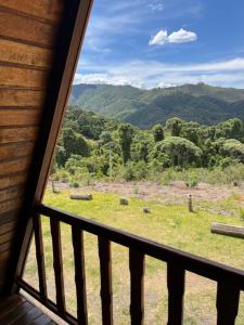 a view of a mountain from a window of a cabin at Chalé Mirante das Estrelas in Camanducaia +9 photos