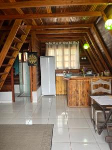 a kitchen with a refrigerator and a table in a room at Chalé Mirante das Estrelas in Camanducaia