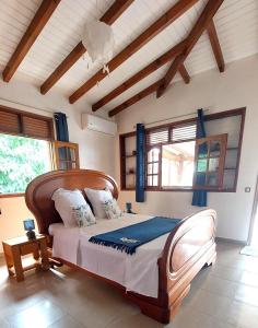 - une chambre avec un grand lit dans une pièce dotée de fenêtres dans l'établissement GRANDE Villa THEANA, à Bouillante