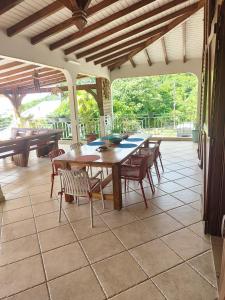 une salle à manger avec une table et des chaises sur un patio dans l'établissement GRANDE Villa THEANA, à Bouillante