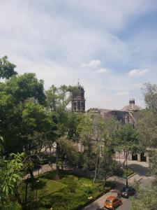 Un coche amarillo estacionado frente a un edificio en Reforma Sky Flat - Steps from Bellas Artes, en Ciudad de México