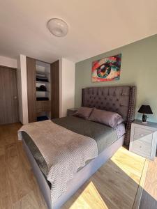 Un dormitorio con una cama y un cuadro en la pared. en Reforma Sky Flat - Steps from Bellas Artes, en Ciudad de México