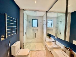 a bathroom with a shower and a toilet and a sink at Apartamento 3 dormitórios quadra da praia in Balneário Camboriú +23 photos
