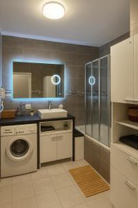 een badkamer met wastafel en wasmachine bij Appartement Luxe - Smart Netflix & Alexa - 10 min La Défense 5 Guests 5 Beds in Bezons