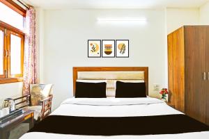a bedroom with a large bed and a dresser at Super Hotel O Sector 45 Formerly Manyavar in Chandīgarh