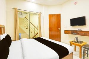 a hotel room with a bed and a television at Super Hotel O Sector 45 Formerly Manyavar in Chandīgarh