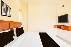 a bedroom with a large bed with a tv on the wall at Super Hotel O Sector 45 Formerly Manyavar in Chandīgarh +44 photos