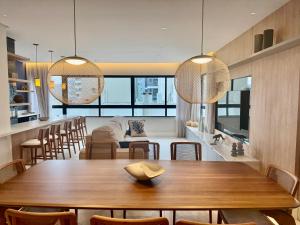 a dining room with a wooden table and chairs at Apartamento 3 dormitórios quadra da praia in Balneário Camboriú