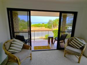 a room with two chairs and a balcony with a view at Beachfront Bliss in Lennox Head