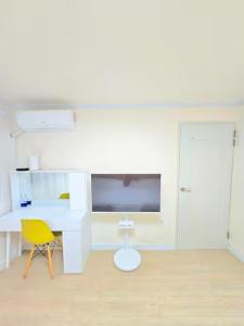a white room with a desk and a yellow chair at Haven 10 HOUSE in Seoul