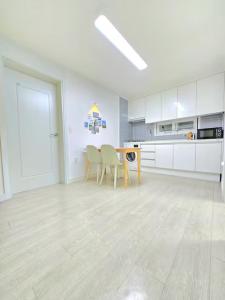 a kitchen with white cabinets and a table and chairs at Haven 10 HOUSE in Seoul