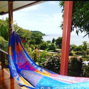 Una hamaca en un porche con vista al mar. en Casa Jade, en Drake