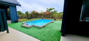 ein Swimmingpool auf einem grünen Rasen mit einem Haus in der Unterkunft Yadua Bay Holiday Homes in Yandua