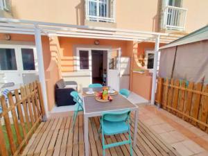 a patio with a table and chairs on a deck at Green Oasis Maspalomas garden 11 in Maspalomas