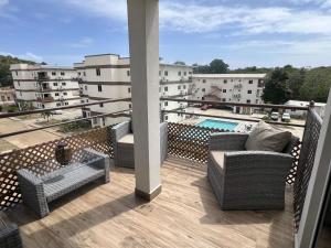 un balcone con sedie e una piscina in un edificio di 4B Holiday Haven a Buccoo