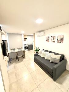 ein Wohnzimmer mit Sofa und Tisch in der Unterkunft Petit Premium Nueva Cba - Oulton in Cordoba