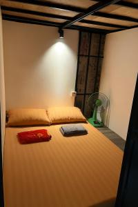 a bedroom with a large bed with a fan at Apiary Capsule 1 in Phnom Penh