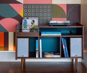a book shelf with books on it in front of a wall at &Tales Hotel - Óbidos in Óbidos