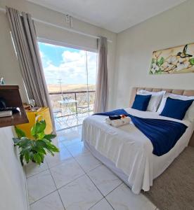 a bedroom with a large bed and a large window at Pousada Loft vista da serra in Serra de São Bento