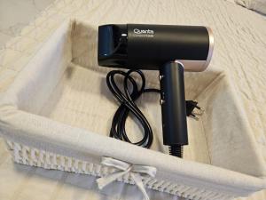 Un secador de pelo en una caja sobre una cama. en Easy Access Apartment - Ciudad del Este, en Ciudad del Este