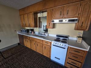 cocina con armarios de madera y horno de fogón blanco en Enchanted Escape Lodge, en Eagle Nest