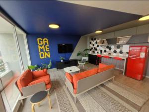 a living room with orange furniture and a red refrigerator at departamento reñaca in Viña del Mar