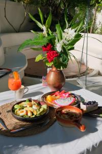 ein Tisch mit Tellern voller Essen und eine Vase mit Blumen in der Unterkunft Fieldlight pool Villa in Mae Rim