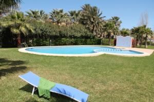 einen Pool in einem Garten mit zwei Gartenstühlen in der Unterkunft Las Olas Denia in Denia